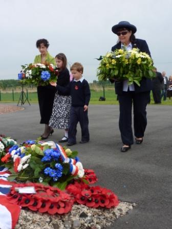 Mrs Victoria Burbidge with her children and Chris Munro lay wreaths during the service